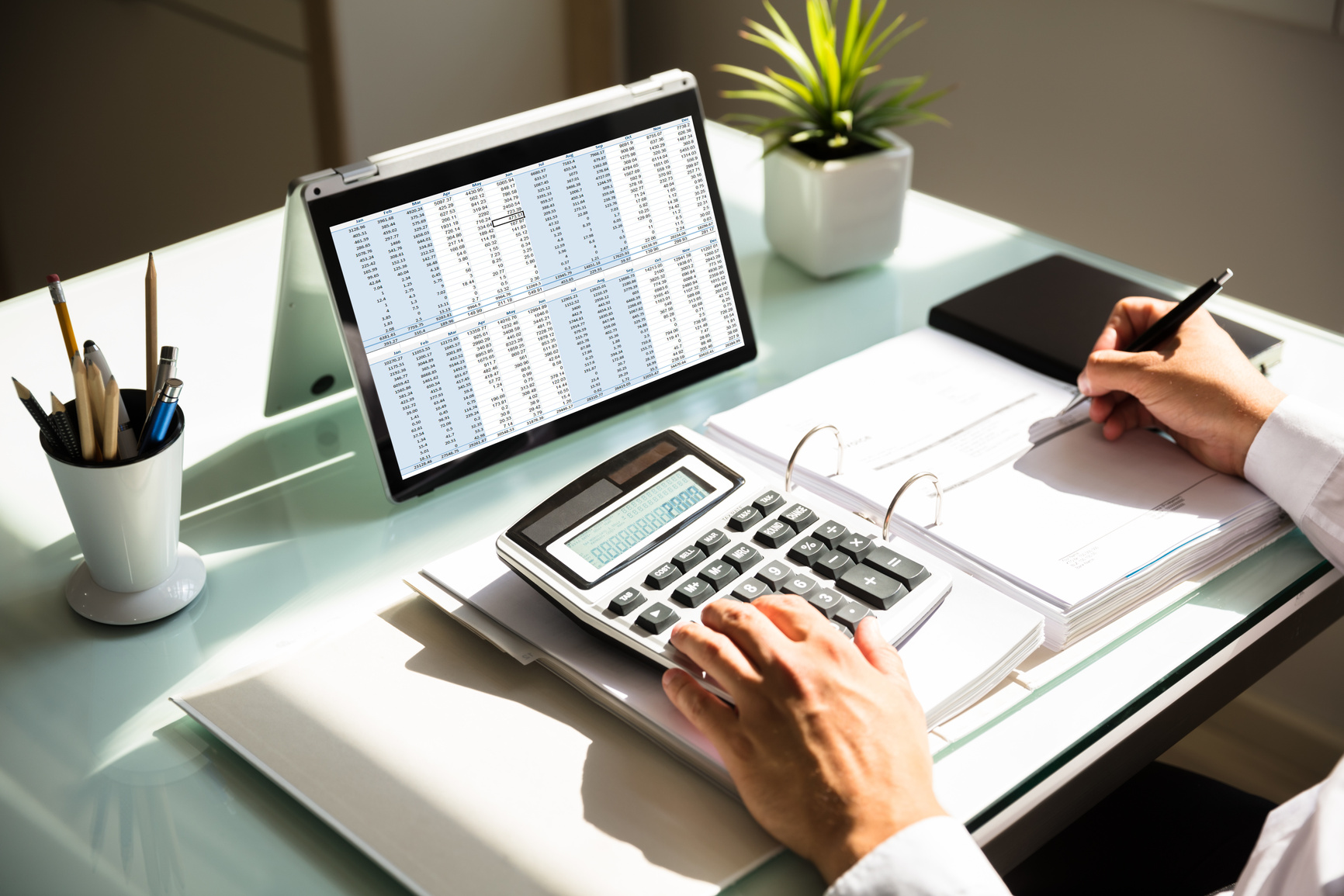 Businessperson Calculating Invoice Using Calculator